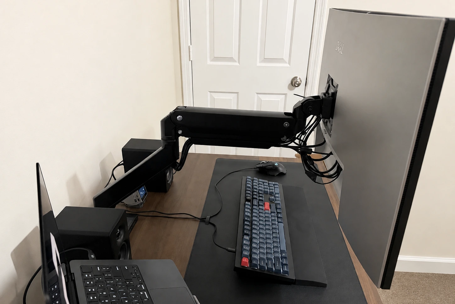 Rear view of the UPLIFT Crestview Single Monitor Arm fully extended behind a 32-inch monitor