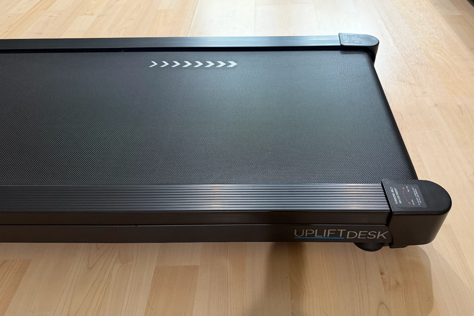 Side view of the black UPLIFT Inclining Walking Pad with the UPLIFT Desk logo visible on its frame